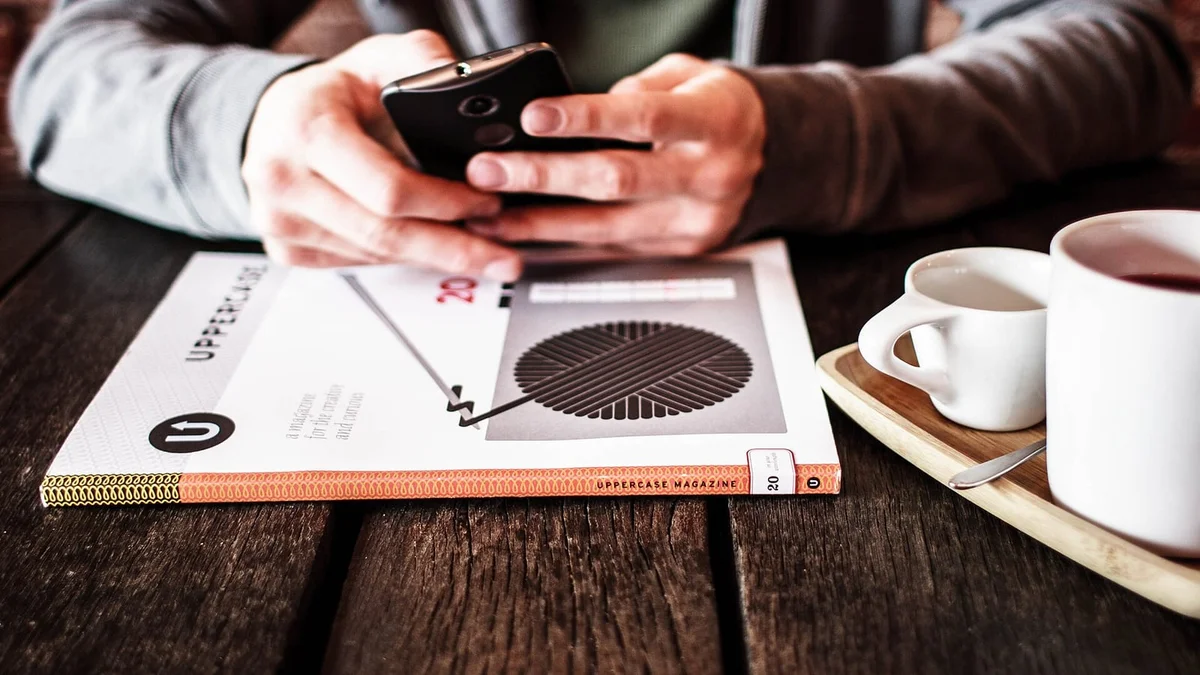 Masada duran akıllı telefon ve bir fincan kahve